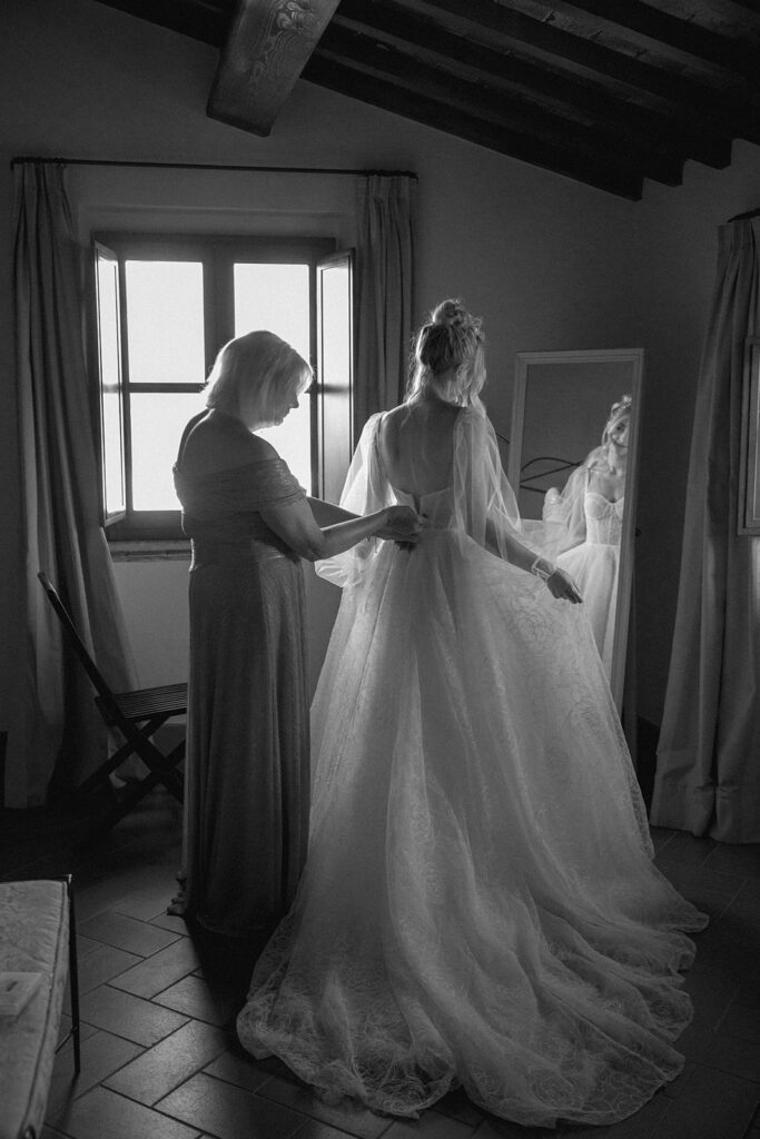 Mom helping bride get ready for wedding 