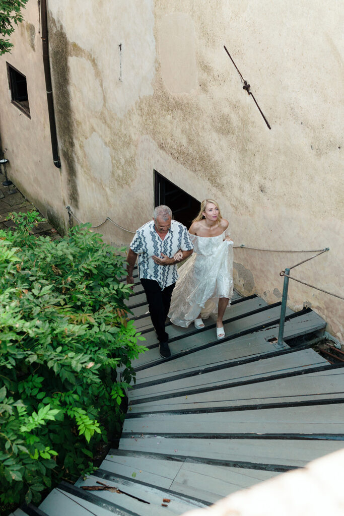 Bride and father walking into venue for rehearsal dinner in italy 