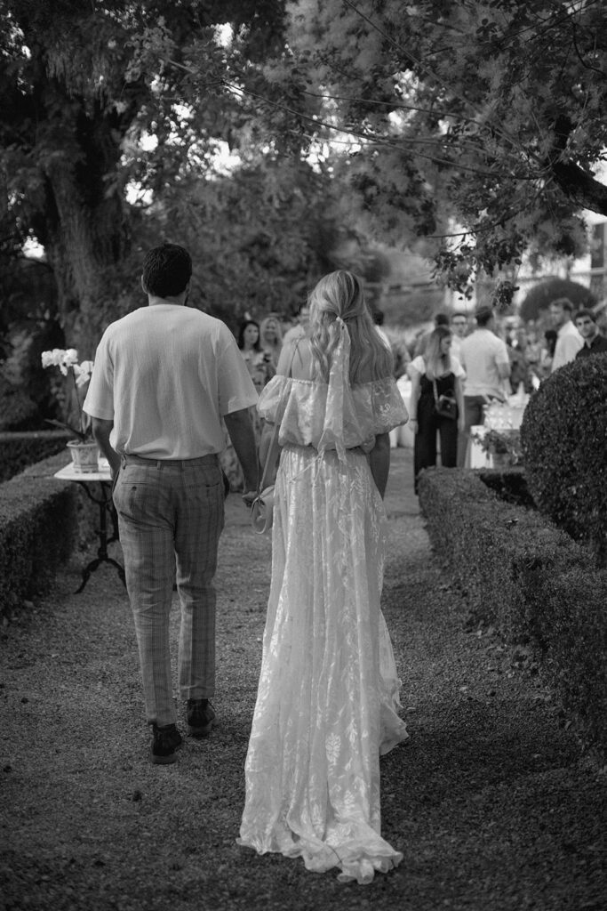 Bride and groom walking into rehearsal dinner in Tuscany 