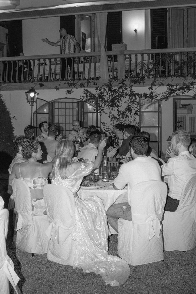 Wedding party holding up a glass during rehearsal dinner speeches 