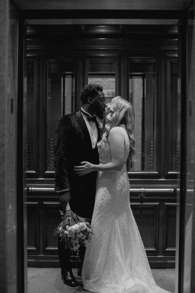 Bride and groom kissing in elevator 