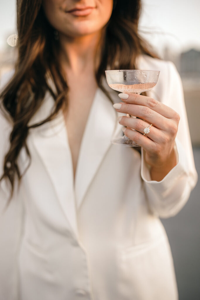 Bride in white suit with engagement ring 