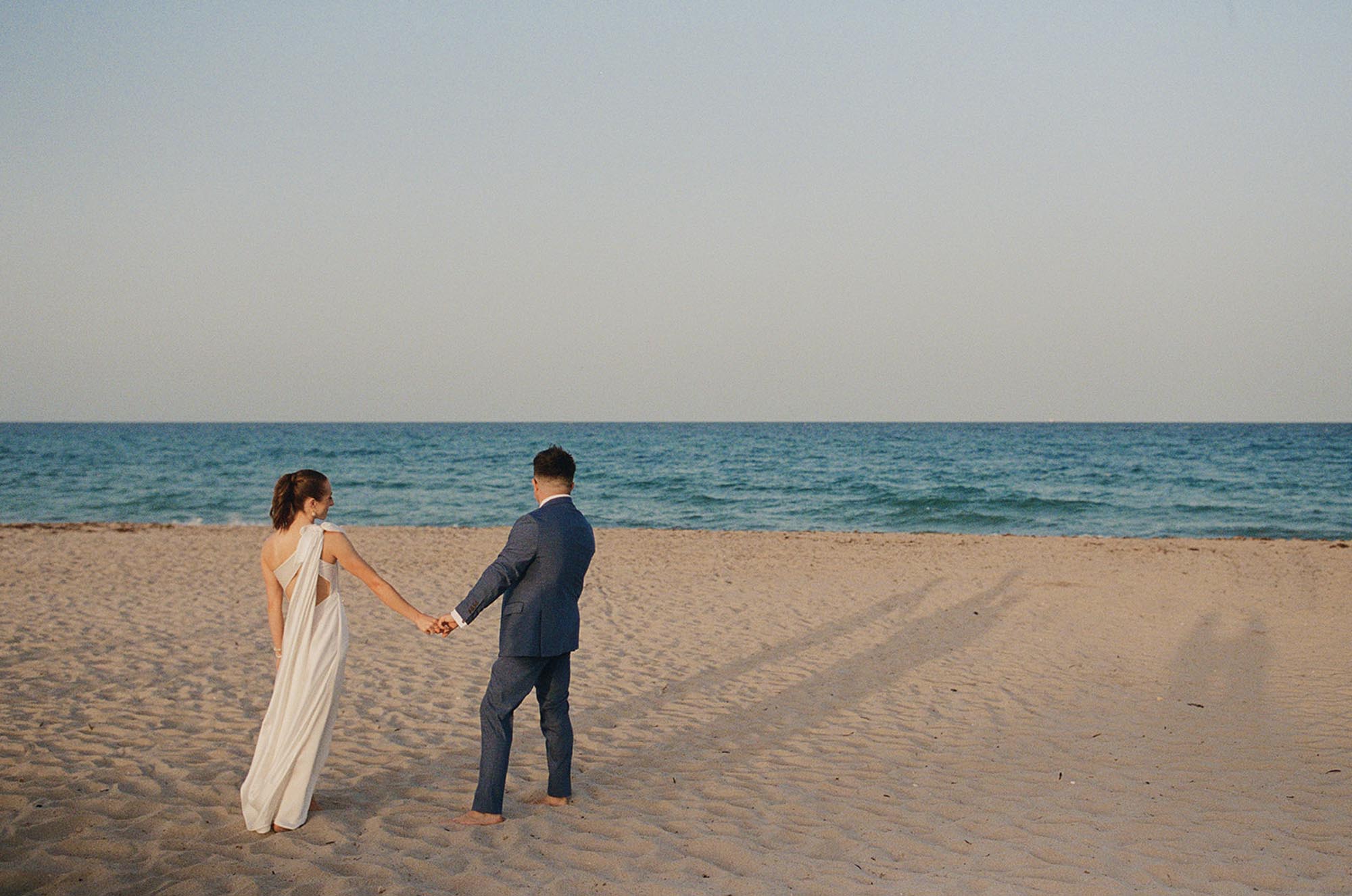 Bride and groom holding hands on Delray Beach, Florida